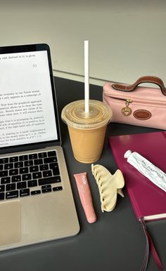 an open laptop computer sitting on top of a desk next to a cup of coffee