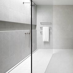 a bathroom with a white towel hanging on the wall next to a walk in shower