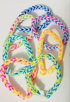 multicolored bracelets are arranged in a circle on a white surface with one knot at the end