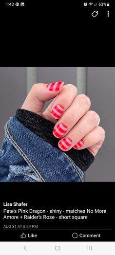 a person with red and white nail polish on their nails is holding up her hand