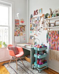 a room with a desk, chair and shelves on the wall above it is a colorful rug