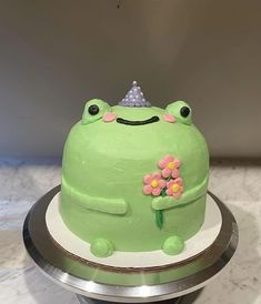 a green frog cake with flowers on top