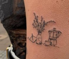 a woman with a tattoo on her leg that has flowers in vases next to it