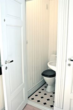 a white toilet sitting in a bathroom next to a black and white checkered floor