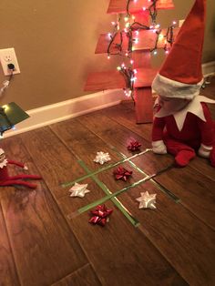 an elf is sitting on the floor with christmas decorations