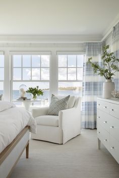 a white bed sitting next to a window in a bedroom