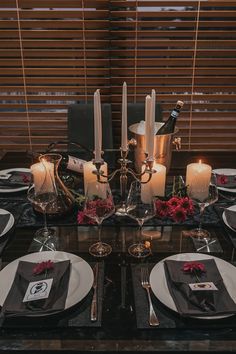 a table set with candles, plates and napkins