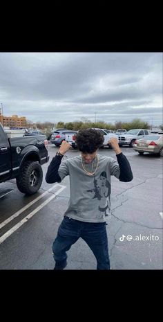 a man standing in the middle of a parking lot with his hands on his head