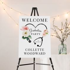 a welcome sign for a graduation party with flowers and a stethoscope on it