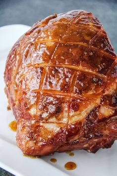 a piece of meat sitting on top of a white plate covered in bbq sauce