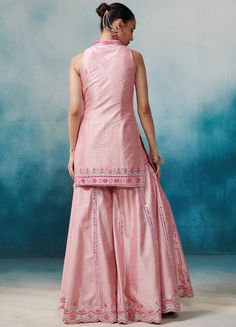 Featuring a pink silk sleeveless kurta with band collar neckline, embellished with gota, zari and mirror applique work. Paired with an embellished garara bottoms and a matching organza dupatta with cutwork border detailing and tassels on hem. An absolute fusion silhouette for Sangeet and Engagement parties. Composition : Kurta & Garara: Slub Silk, Dupatta: Organza Care: Dry Clean Only and Vacuum Storage All products can be customised for sleeves, length of blouse and neck design Delivery : 6-8 weeks as the product is hand crafted. Check Size Guide or choose MySize for free customisation (All Sizes above XL can be made at 15% additional cost) For more information and sizes please contact fabiliciousfashion@gmail.com or visit our Copenhagen studio. Sleeveless Kurta, Pink Kurta, Mirror Embroidery, Organza Dupatta, Silk Dupatta, Band Collar, Kurta Set, Cut Work, Pink Silk