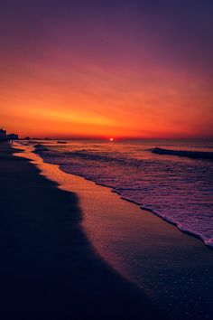 the sun is setting over the water at the beach