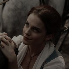 a woman in white shirt sitting next to a horse