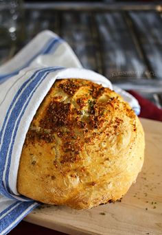 a loaf of bread sitting on top of a wooden cutting board