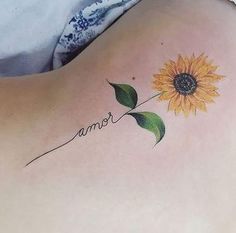 a sunflower tattoo on the back of a woman's shoulder