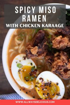 spicy miso ramen with chicken karaage in a white bowl topped with hard boiled eggs and garnishes