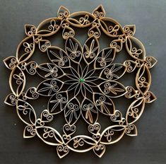 an intricately designed wooden broochle on a black surface