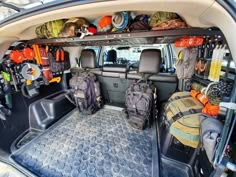 there are many backpacks and bags in the back of this vehicle, as well as other items