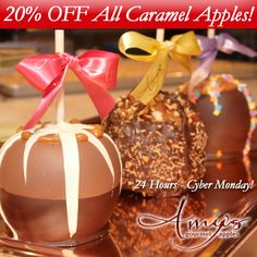 three chocolate covered candies on a tray with ribbons and bows, one is half caramel apples