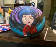 a painted pumpkin sitting on top of a table