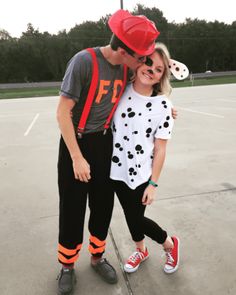 a man and woman in matching outfits pose for a photo on an empty basketball court