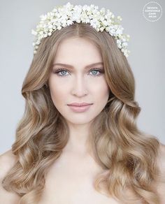 a woman with long blonde hair wearing a white flower crown