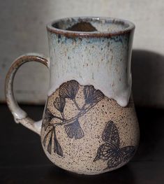 a blue and white coffee mug sitting on top of a table