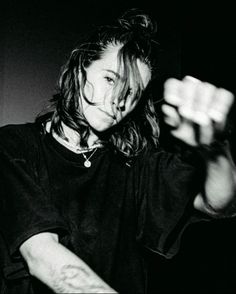 a black and white photo of a woman with her hands in the air while holding something