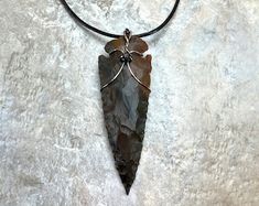 a necklace with a large piece of stone hanging from it's side