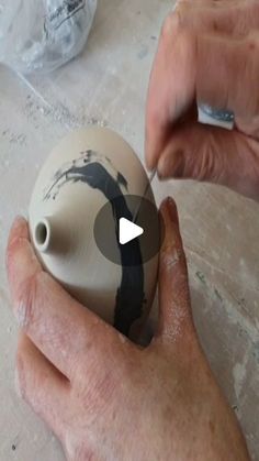 a person is painting a vase with black and white paint on the outside of it