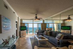 a living room filled with furniture and a flat screen tv mounted to the side of a wall