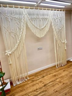 a room with wooden floors and white curtains