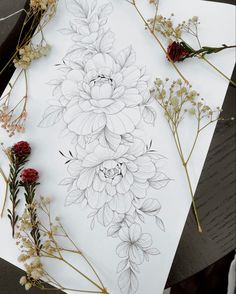 some flowers are laying on top of a piece of paper with pencils and ink