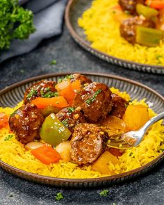 two plates filled with yellow rice and meatballs