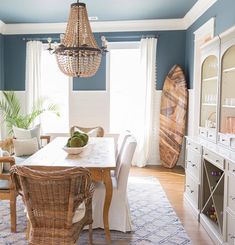 a dining room with blue walls and white furniture