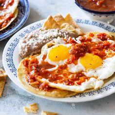 two plates with breakfast foods on them, one has eggs and the other has salsa