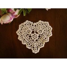 a crocheted doily on a table next to flowers