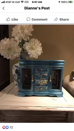 a blue cabinet with white flowers in it