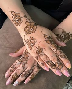 a woman's hands with hennap and flowers on them