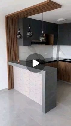 an empty kitchen with black cabinets and marble counter tops in front of a white wall