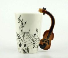 a coffee cup with musical notes on it and a violin in the mug's handle