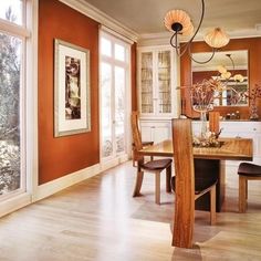 a dining room table and chairs in front of large windows