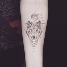 a tattoo on the arm of a woman with a wolf head and geometrical design