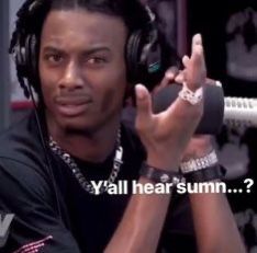 a man wearing headphones and holding a microphone in front of him with the words y'all hear summ?