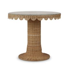 a wicker table with scalloped edges and a glass top on an isolated white background