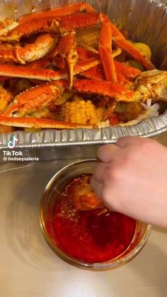 a person dipping some food into a bowl