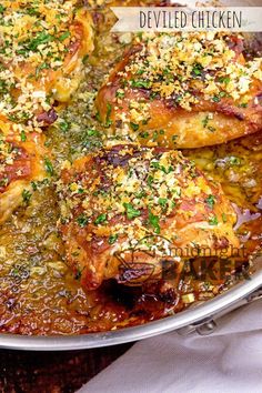 baked chicken with parmesan cheese and herbs in a skillet on a wooden table