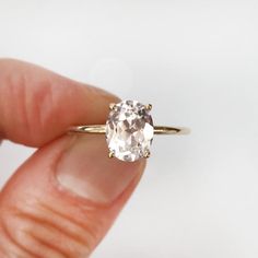 a woman's hand holding an engagement ring with a large white diamond in it