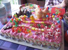 a table topped with lots of candy and candies on top of a cake covered in icing