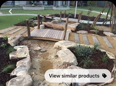 a wooden bridge over a small pond surrounded by rocks